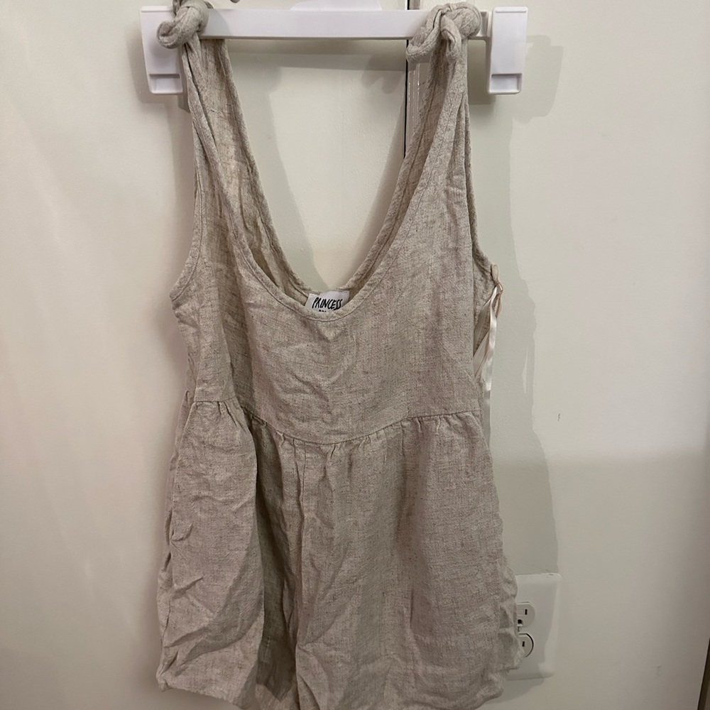 Tan romper with shoulder tie straps. Also has pockets. Very short, never worn.